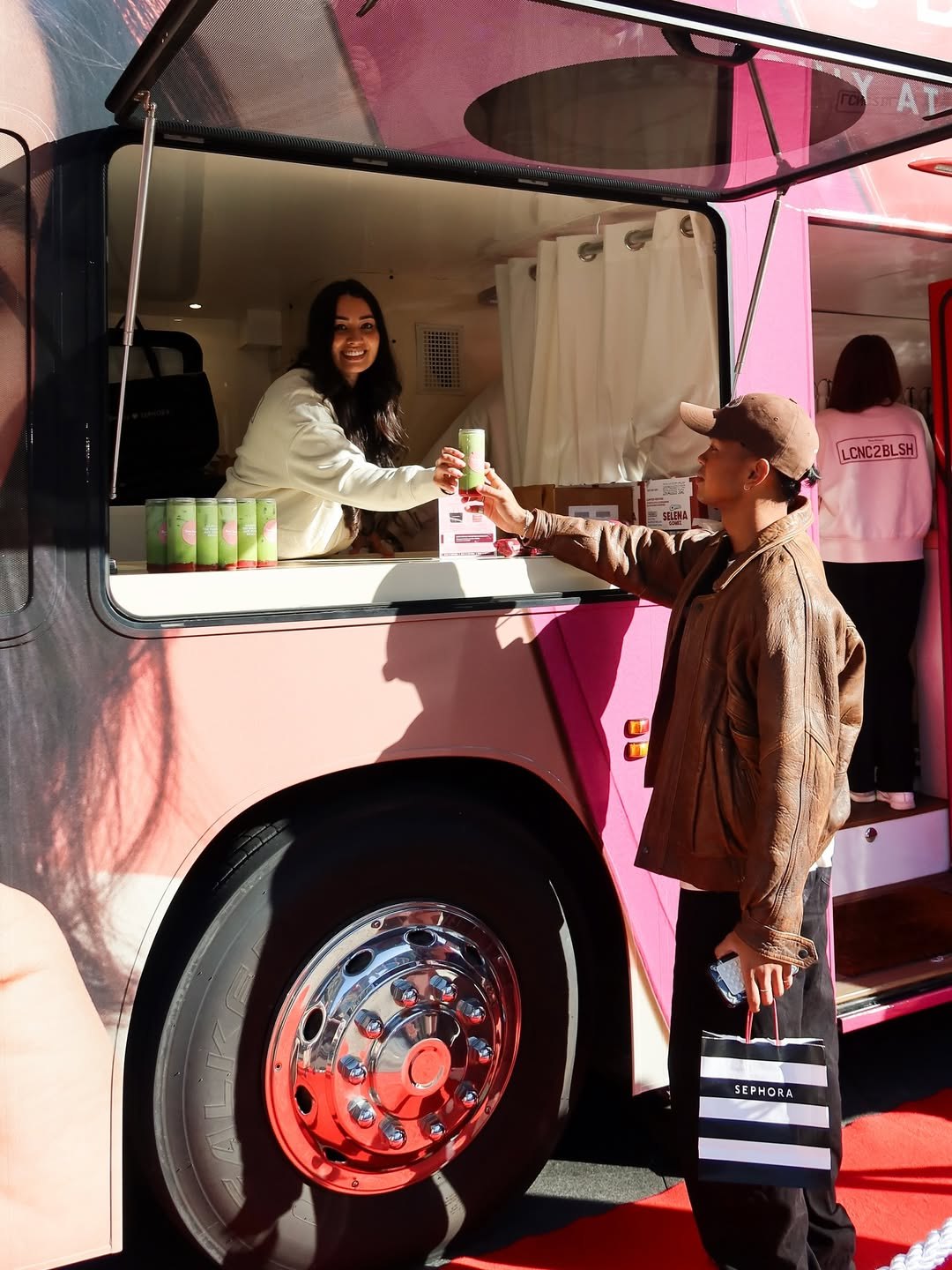Rare Beauty team member serving a visitor from the bus counter